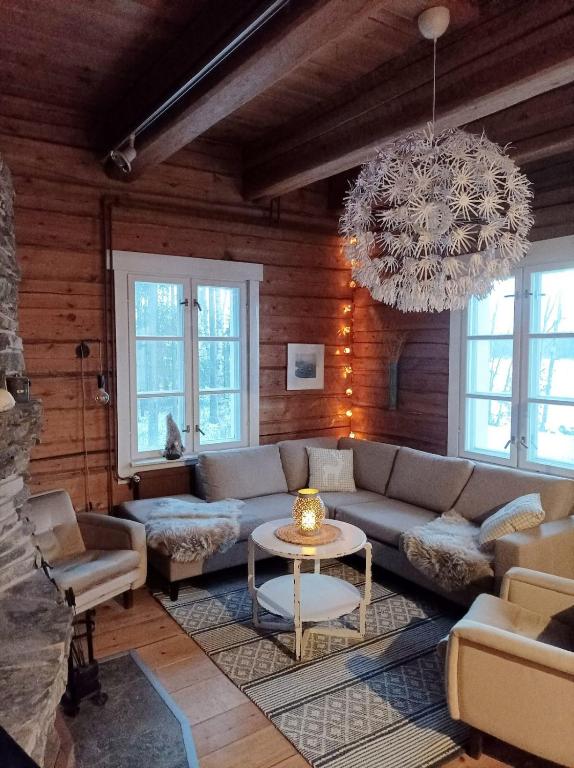 a living room with a couch and a chandelier at Arctic house in Rovaniemi