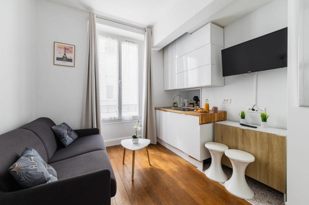 un salon avec un canapé et une cuisine dans l'établissement Studio equipe centre nation - Paris 12 - 2P - FLAT-GUEST, à Paris