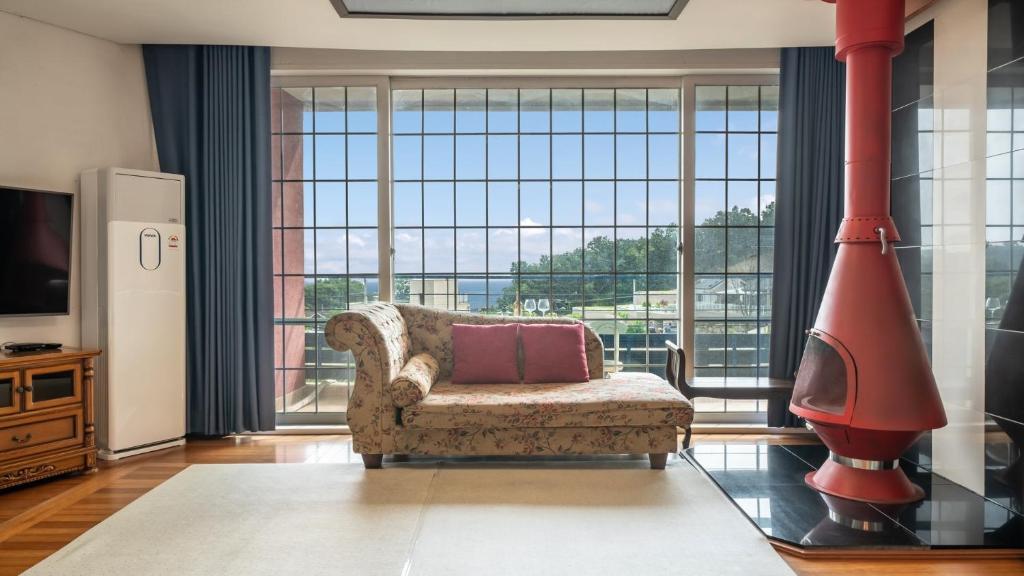 un salon avec un canapé et une grande fenêtre dans l'établissement Ganghwado Happyvilly Pension, à Incheon