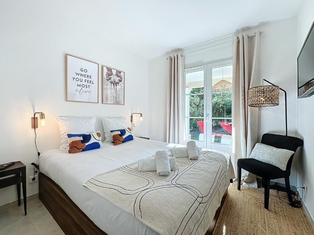une chambre avec un lit, une chaise et une fenêtre dans l'établissement Les oliviers St Tropez et plage à pied - 22, à Saint-Tropez