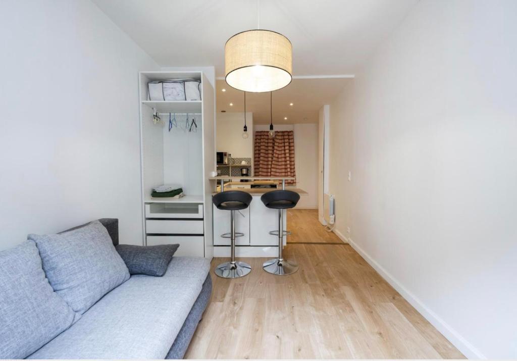 ein Wohnzimmer mit einer Couch und zwei Barhockern in der Unterkunft Studio centre historique Bayonne 5 in Bayonne