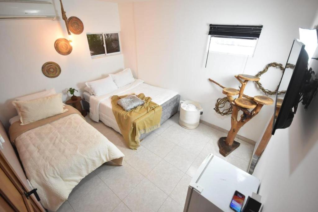 a small bedroom with two beds and a window at Cartagena Hotel Boutique - Manga - Tierra del Mar - Colombia in Cartagena de Indias
