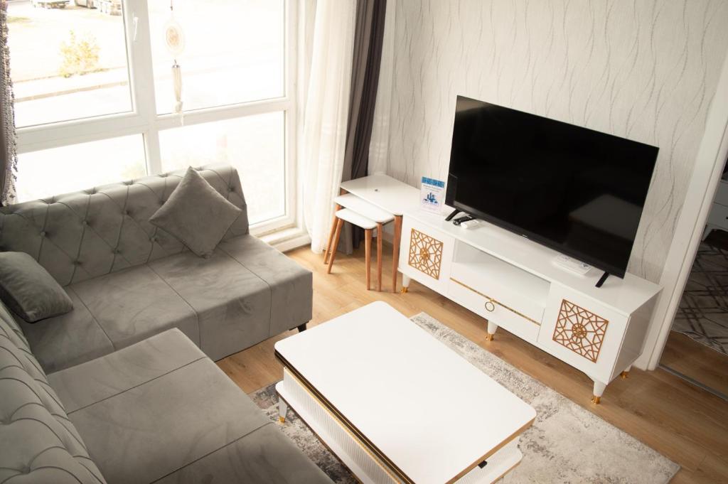 a living room with a couch and a flat screen tv at Classic Suite AA7 in Esenyurt