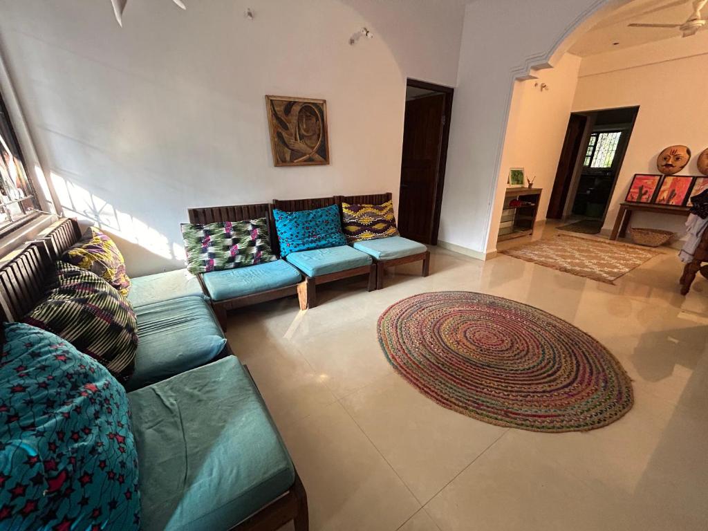 una sala de estar con un sofá y una alfombra en Home from Home, en Canacona