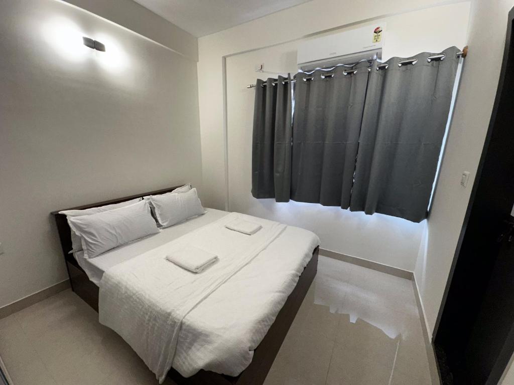 a small room with a bed with a black curtain at Trinetra Homes 102 in Bengaluru
