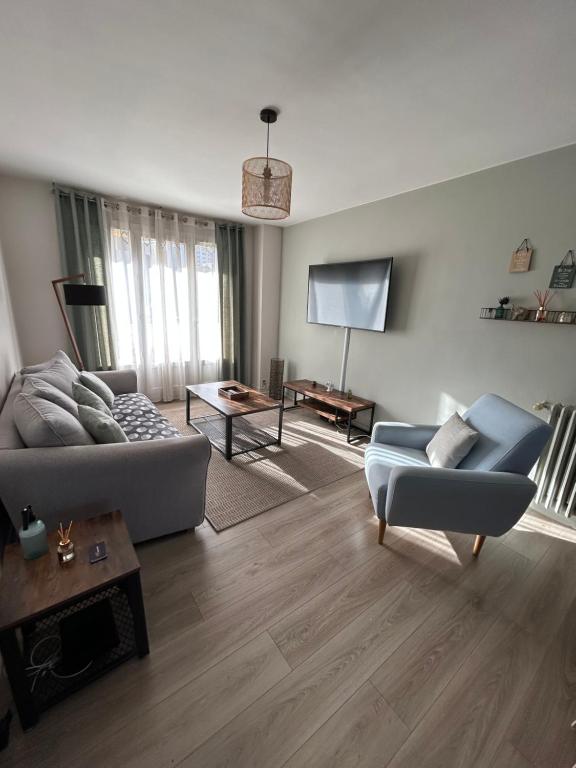 un salon avec un canapé et une télévision dans l'établissement T3 résidence BEL AIR - Limoges - CHU - parking, à Limoges