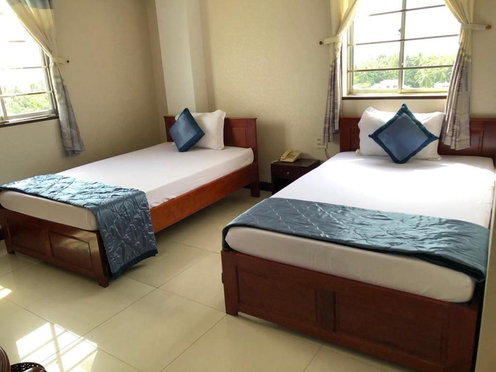 Postel nebo postele na pokoji v ubytování Thành Đạt Hotel Bạc Liêu