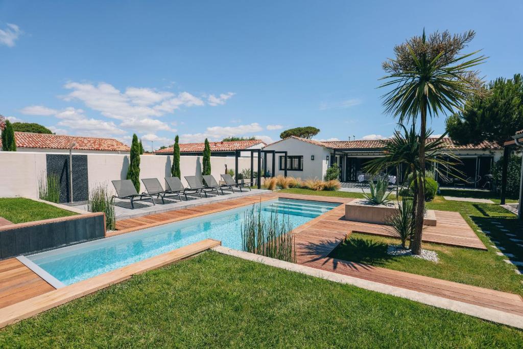 une cour arrière avec une piscine et une maison dans l'établissement Villa Dune, au Bois-Plage-en-Ré