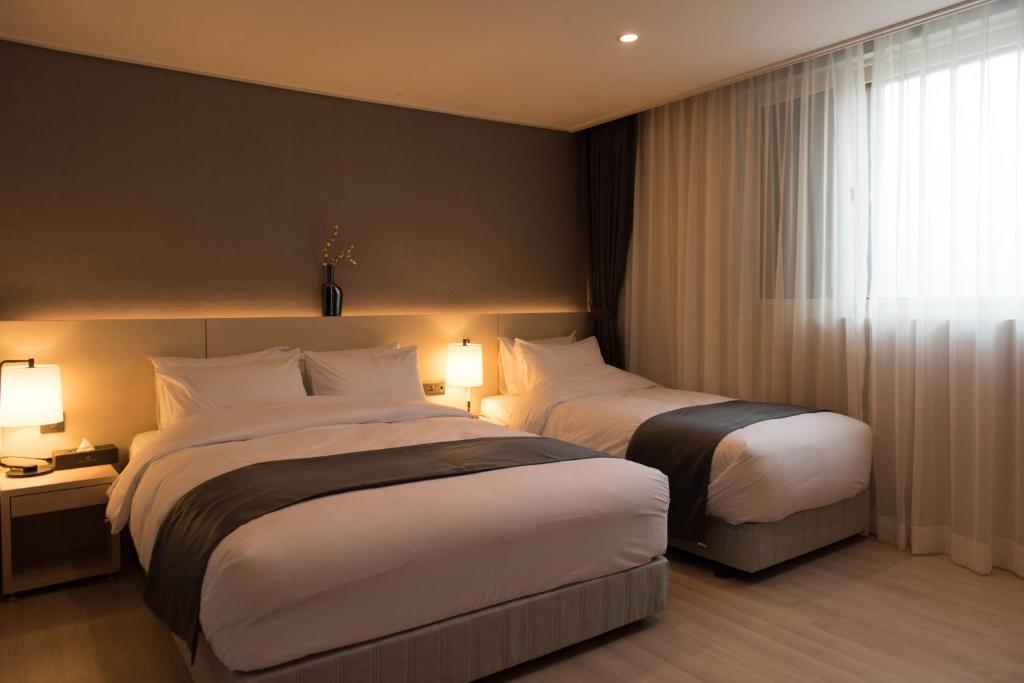 Postel nebo postele na pokoji v ubytování New Donghae Tourist Hotel