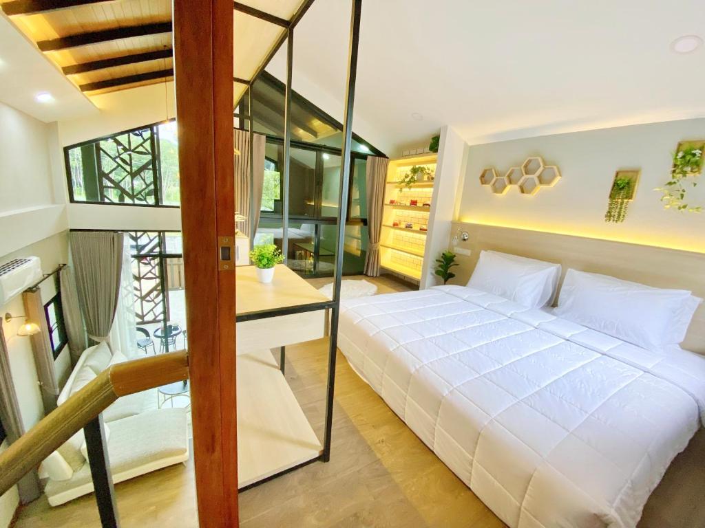 una camera da letto con un grande letto bianco e una scrivania di Ploy Mountain View Pool Villa a Ban Thai Thai