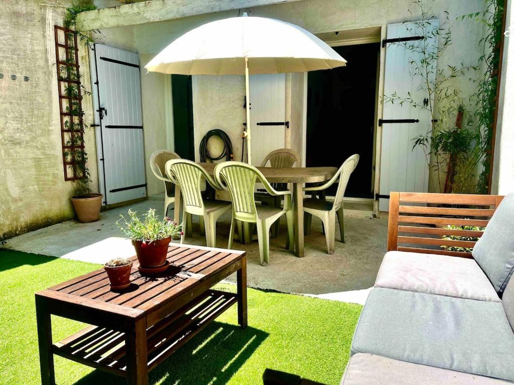 un patio avec une table, des chaises et un parasol dans l'établissement Two rooms and large terrace, à Montpellier
