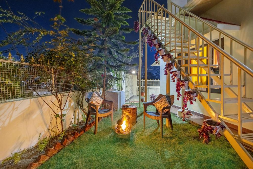 a patio with chairs and a staircase at night at Alaya Stays Cozy Nest 2 BHK Cottage with Garden in Bhīm Tāl