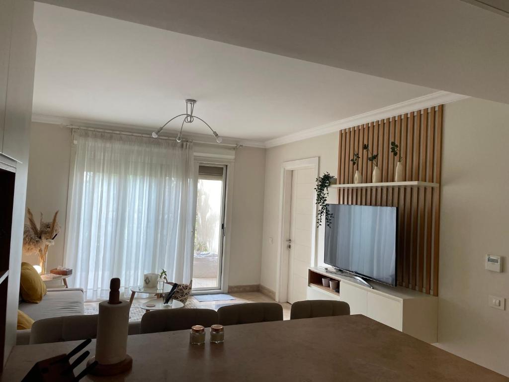 Μια τηλεόραση ή/και κέντρο ψυχαγωγίας στο Cozy ground 1 BD apt in New Giza