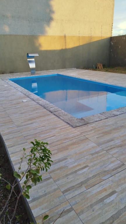 a swimming pool on a wooden deck at Casa agradável e confortável, com piscina in Bonito