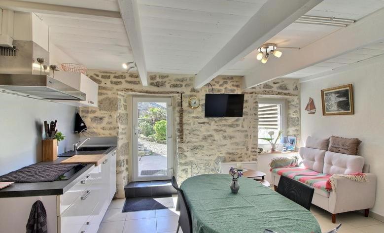 a kitchen and living room with a couch and a table at Ty Chann Rouz in Ile de Sein