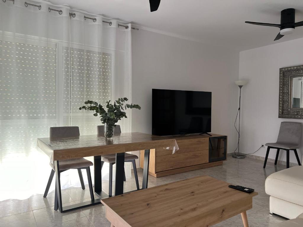 a living room with a table and a television at Iberia home beach in Águilas