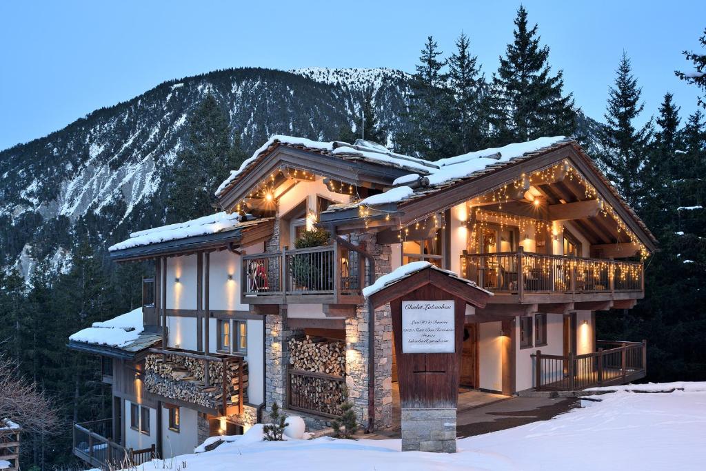 a log cabin in the mountains with snow on the ground at Chalet Labaobou Courchevel 1650 in Courchevel