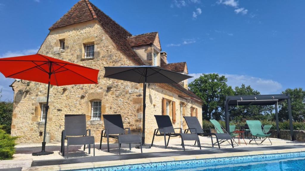 - un groupe de chaises longues et de parasols à côté de la piscine dans l'établissement Le bousquet, à Bars
