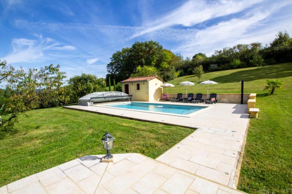 une cour avec une piscine et une pelouse dans l'établissement Le pech 4, à Badefols-sur-Dordogne
