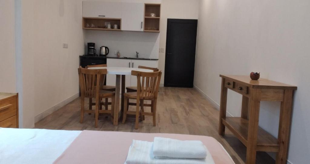 a room with a kitchen and a table and chairs at Monoambiente céntrico con cochera Aloj URQUIZA in Concordia