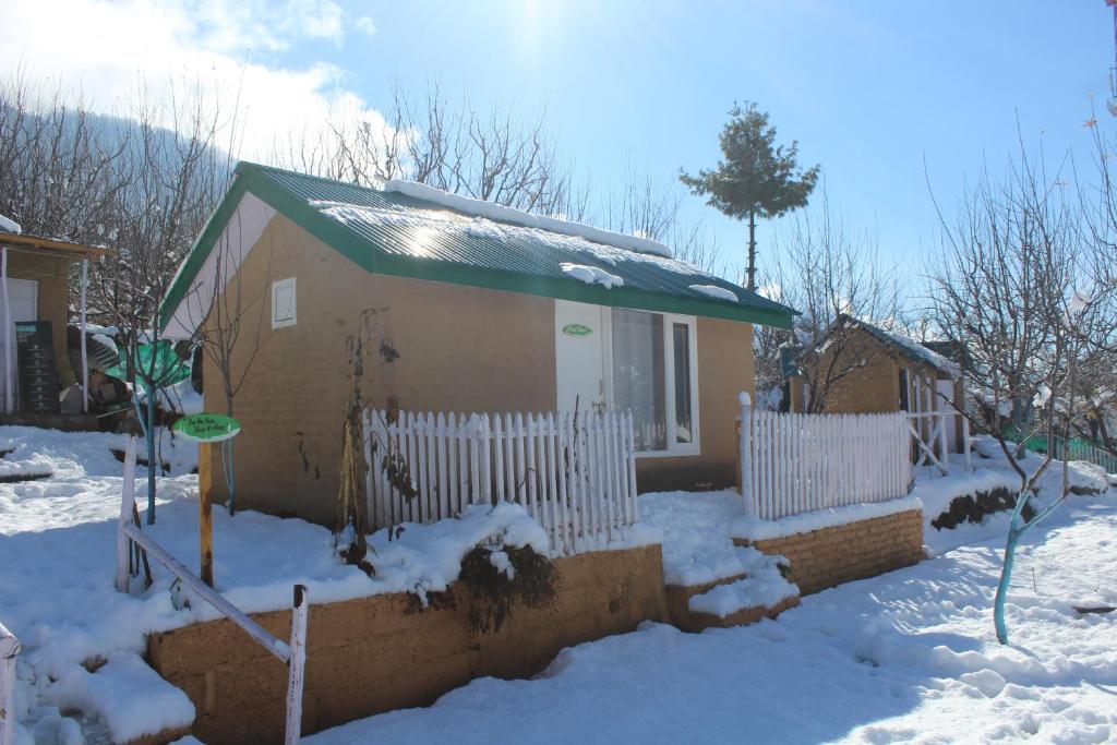 uma pequena casa com uma cerca na neve em Enthralling Escapes Nature Stay and Trek em Manali