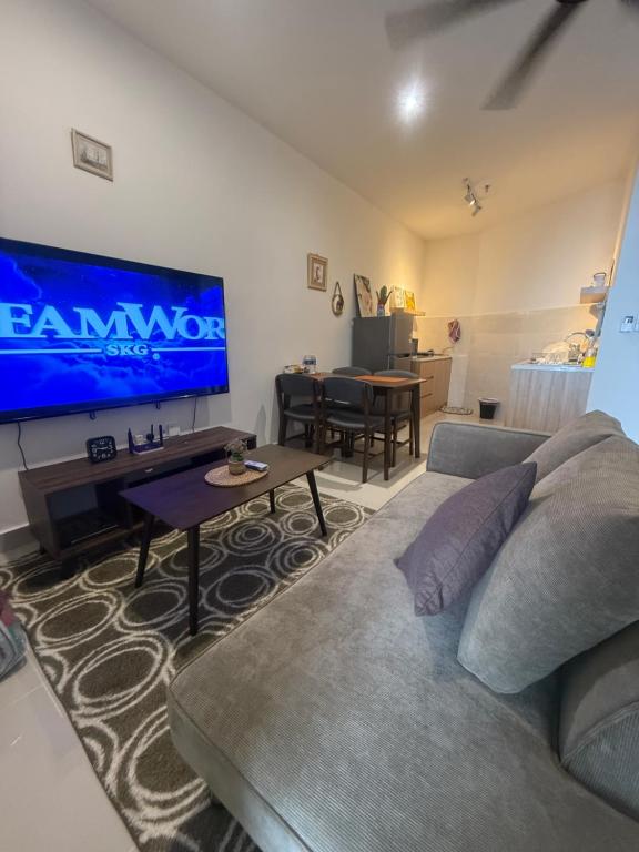 a living room with a couch and a large screen tv at MMJ Homesuite @ The Shore in Kota Kinabalu