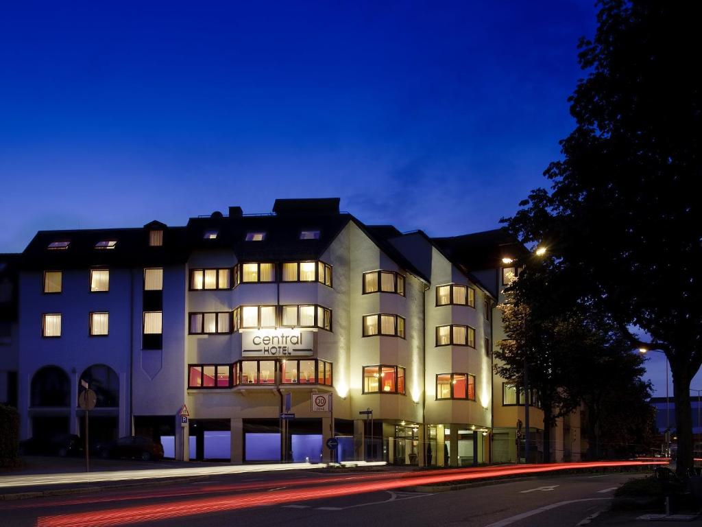 フィリンゲン・シュヴェニンゲンにあるCentral Hotelの夜間の照明付き窓のある白い大きな建物
