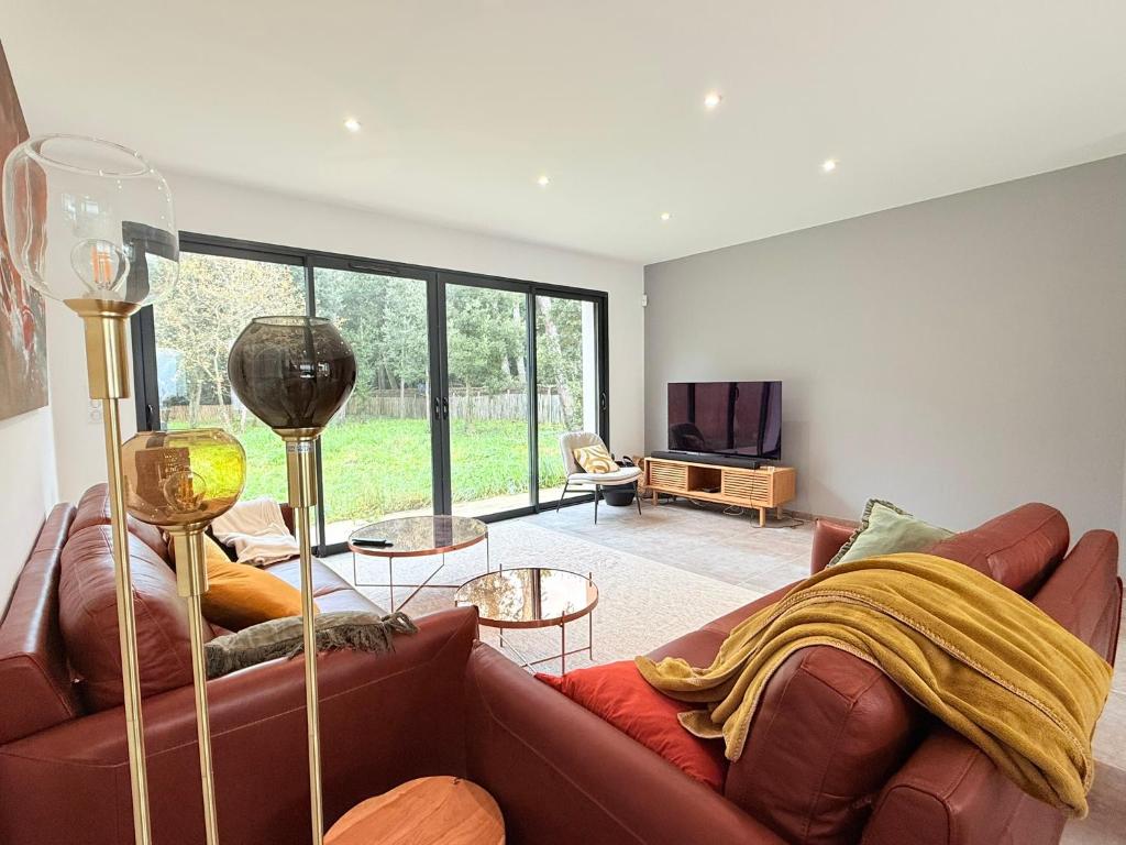 un salon avec un canapé et une télévision dans l'établissement Maison haut standing près de la plage, à Saint-Pierre-dʼOléron