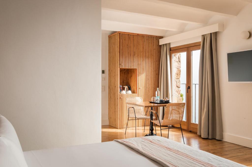 a bedroom with a desk and a table with chairs at BYPILLOW Cap Sa Sal in Begur