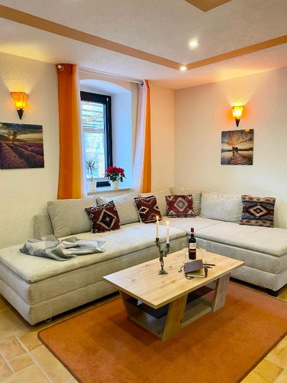 a living room with two couches and a coffee table at Ferienwohnung auf dem Gutshof Renz in Weißenfels