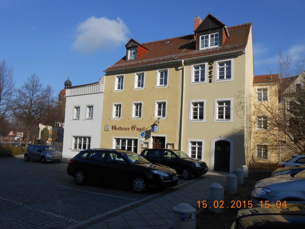 ein gelbes Gebäude mit davor geparkt in der Unterkunft Goldener Engel /Pension in Görlitz