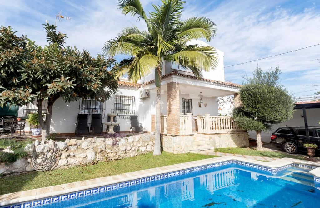 dom z palmą i basenem w obiekcie Villa Ana María w mieście Torremolinos