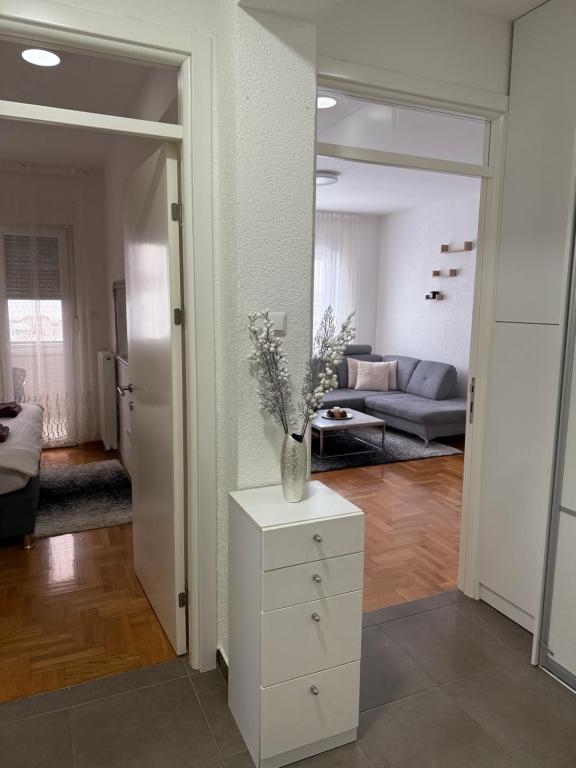 a living room with a vase on a dresser at City Apartment Banja Luka sa Parkingom u garazi in Banja Luka