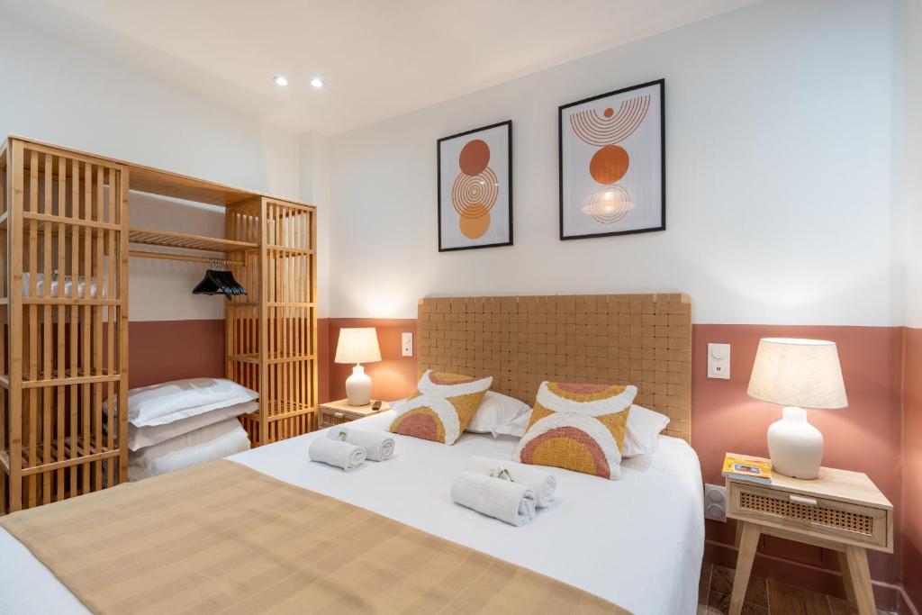 une chambre avec un grand lit blanc avec des oreillers dans l'établissement NEW - Designer Flat for 4 pp, à Paris