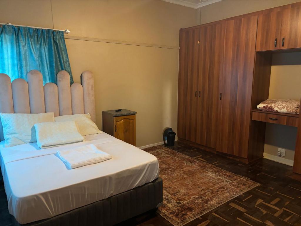 a bedroom with a large bed with a large headboard at RMK Guest house Zeerust in Zeerust