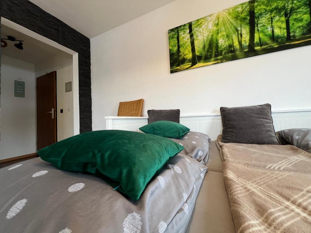 a living room with a couch and green pillows at Ferienwohnung Sole Della Sera in Reichersbeuern