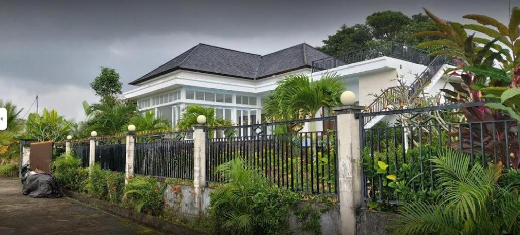 een wit huis met een hek ervoor bij Amber Bali - Villa with serenity in Tabanan