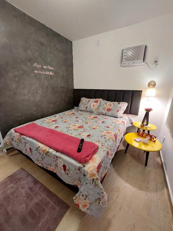 a small bedroom with a bed and a table at Studio Nosso Sonho in Cabo Frio