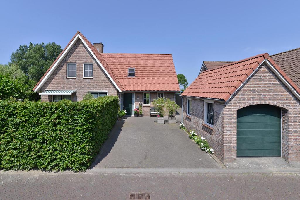 une maison avec une allée et un garage dans l'établissement Augustinushof 13, à Vrouwenpolder