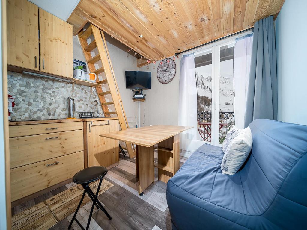 Cette petite chambre dispose d'un canapé bleu et d'une table. dans l'établissement Petit ours I N 83 - 2P5D, à Allos