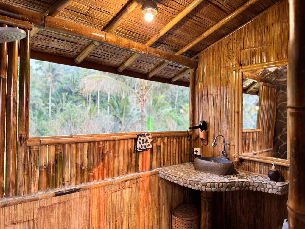 a wooden bathroom with a sink and a window at Tengah Uma Villa Sangketan in Tabanan