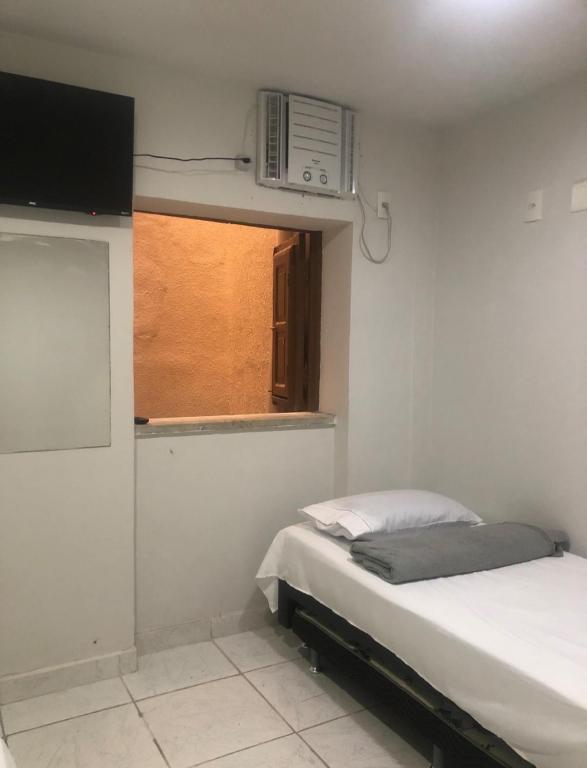 a small bedroom with a bed and a window at Suíte 304 - Pousada no Centro do Rio in Rio de Janeiro