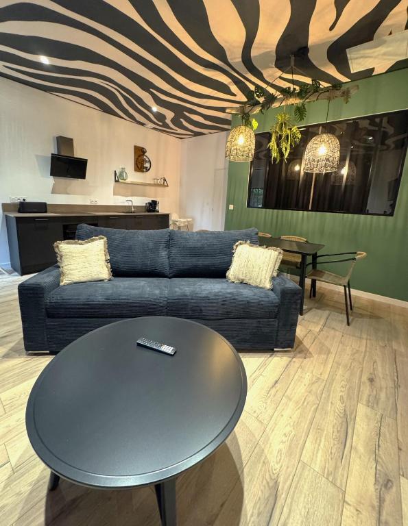 un salon avec un canapé bleu et une table dans l'établissement Studio Savane, 6 min du Zoo, à Seigy