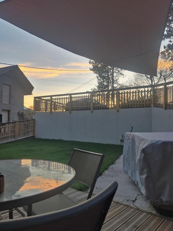 un patio avec une table et des chaises dans une cour dans l'établissement Appartement 38m2 cadre champêtre, à Taninges