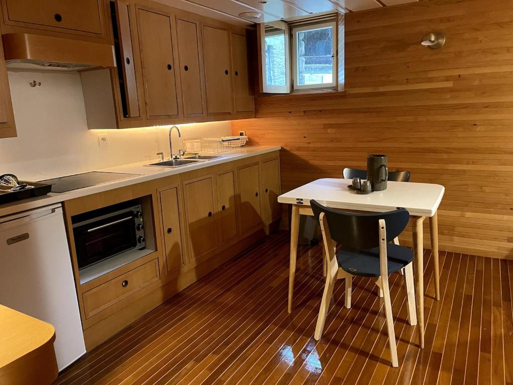 - une cuisine avec une petite table et un évier dans l'établissement le sinagot, à La Celle-sous-Gouzon