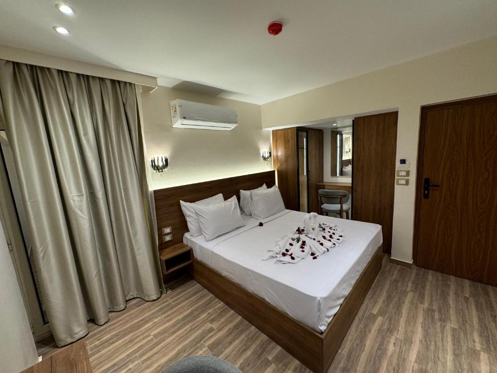 Habitación de hotel con cama con sábanas blancas en Tourist Palace Residence, en El Cairo