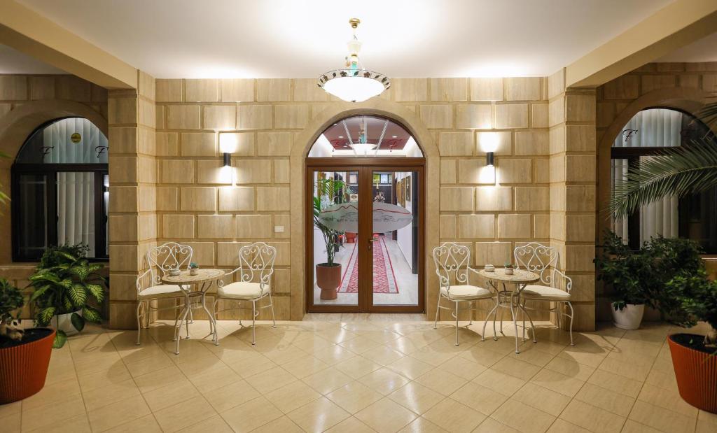 eine Lobby mit Tischen und Stühlen in einem Gebäude in der Unterkunft Hotel Mimani in Berat