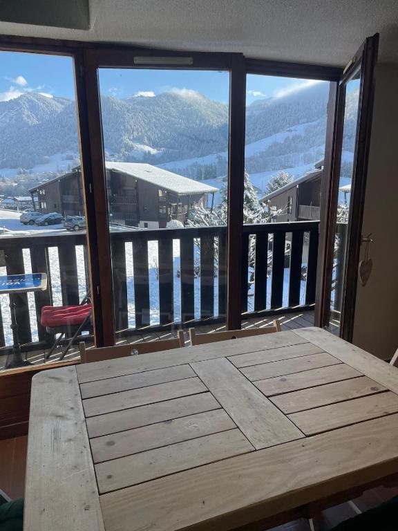d'un balcon avec une table et une vue sur les montagnes. dans l'établissement Appartement 6 pers proche des pistes, à Praz-sur-Arly