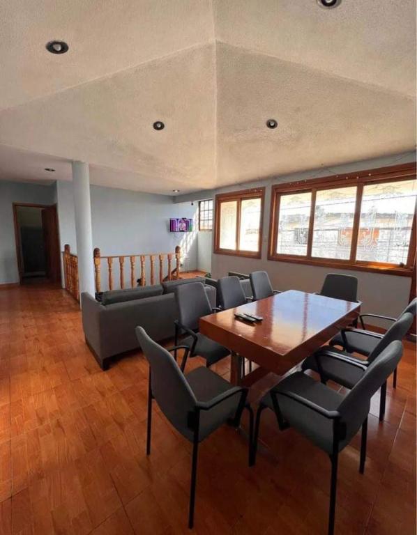 a dining room with a table and chairs and a couch at Habitación doble CAPU in San Felipe Hueyotlipan