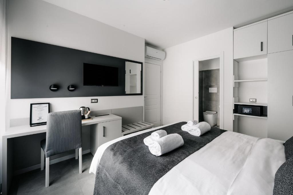 una camera da letto in bianco e nero con letto e scrivania di B&B LUMAS a Roma